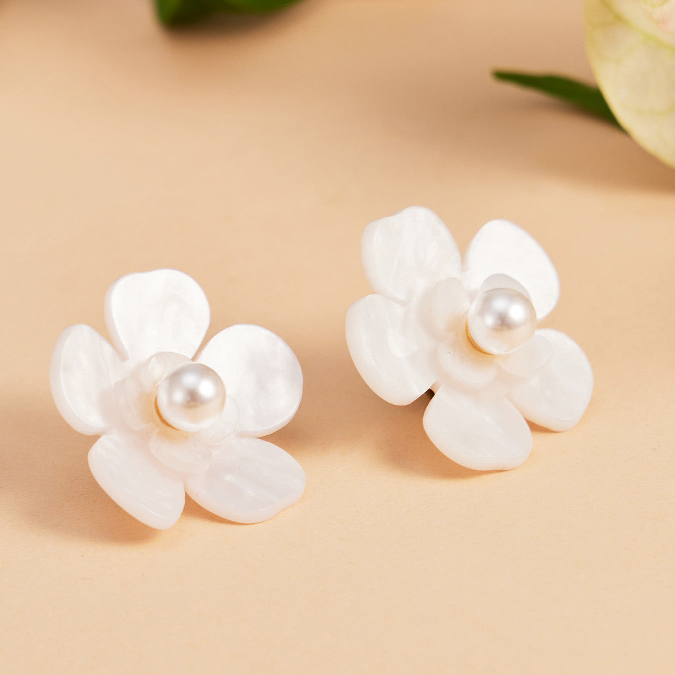 Neutral flat lay of white pearl flower stud earrings