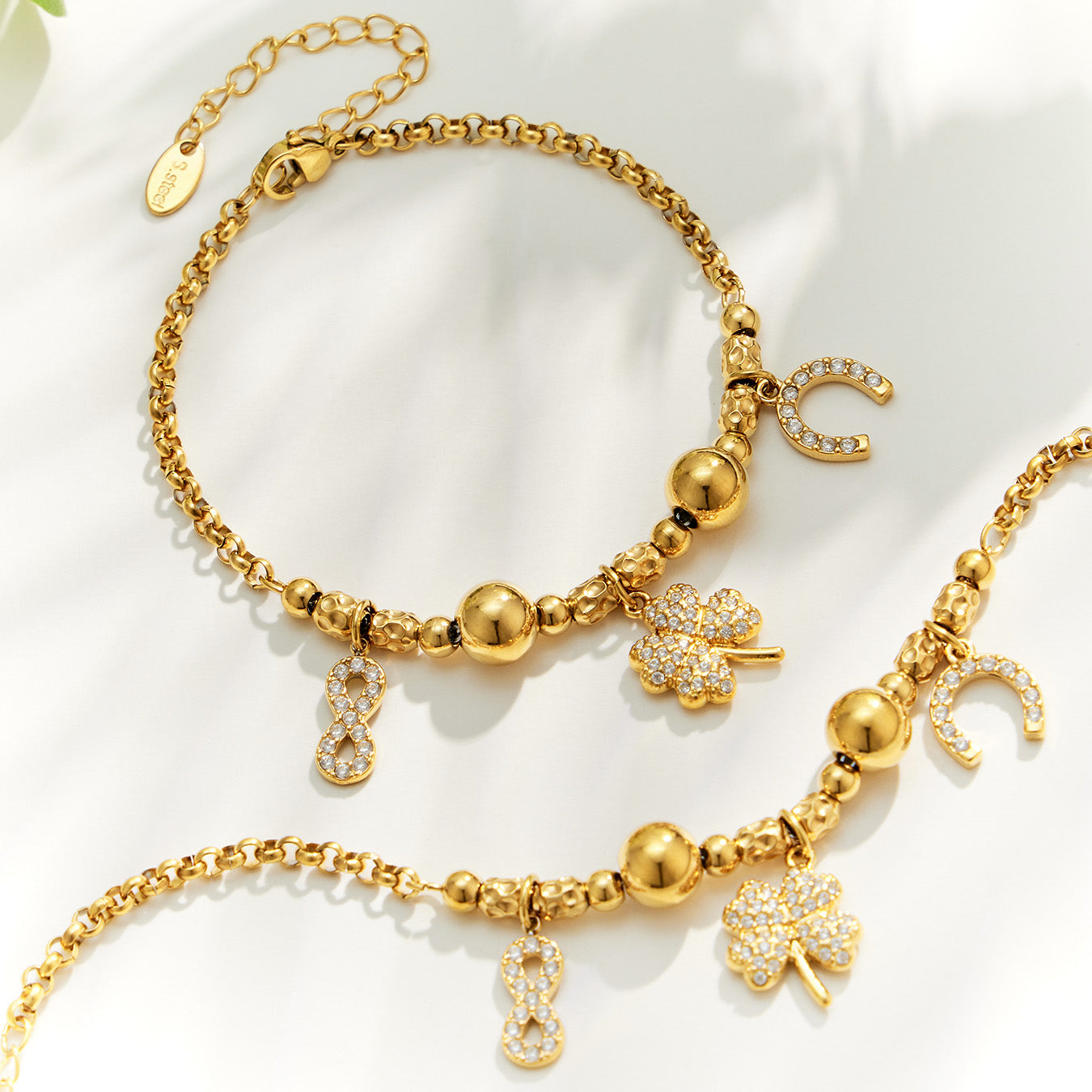 Gold multi charm bracelet designs with mixed pendants and polished bead details