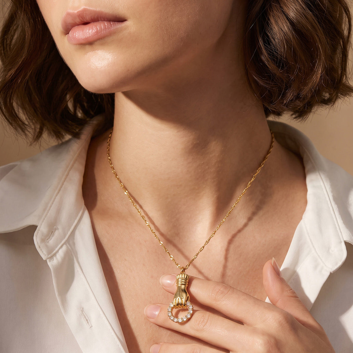 Delicate gold stainless steel chain necklace with zircon pendant worn on model