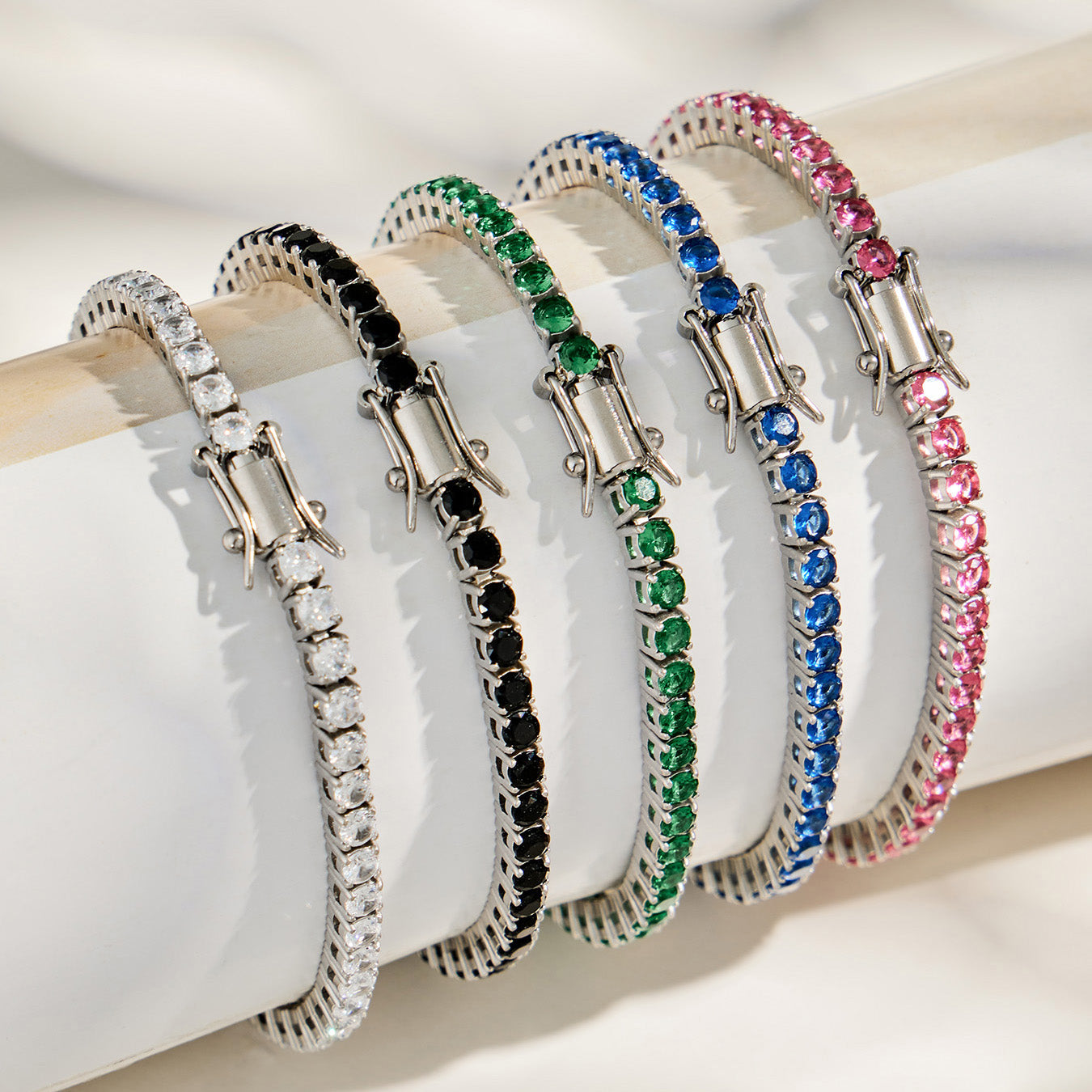 Steel-tone colorful cubic zirconia tennis bracelets displayed on stand in stainless steel