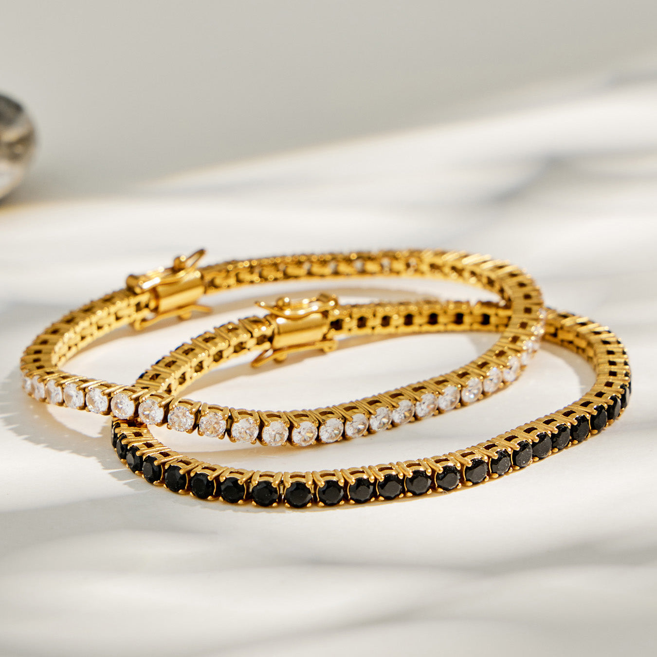 Pair of 18K PVD gold tennis bracelets with cubic zirconia stones product shot on white background