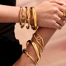 Hands stacked with 18K gold plated luxury bangle set, high-end fashion jewelry