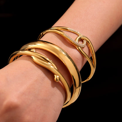 Closeup of 18K gold plated bangles stacked on wrist, sparkling zircon design