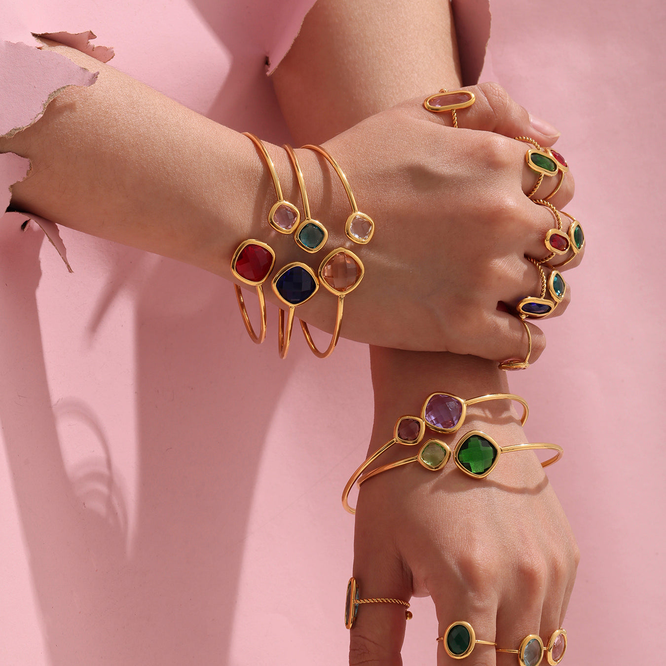 Hands stacked with 18k gold Czech glass stone open bangles and rings, trendy light luxury style