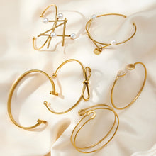 18K gold geometric line & pearl open bangle set displayed on silk, high-end fashion accessory