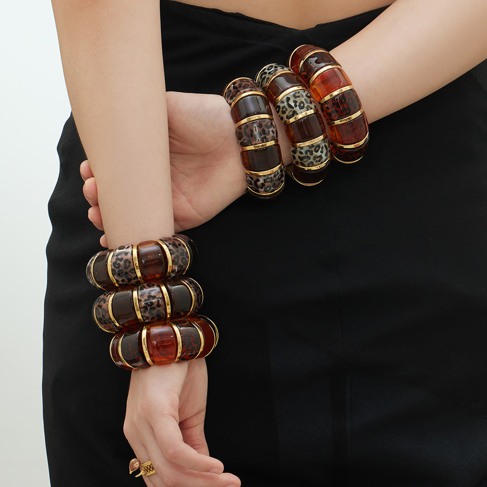 model wearing 18k gold leopard print resin stainless steel bracelets on both arms, bold fashion look