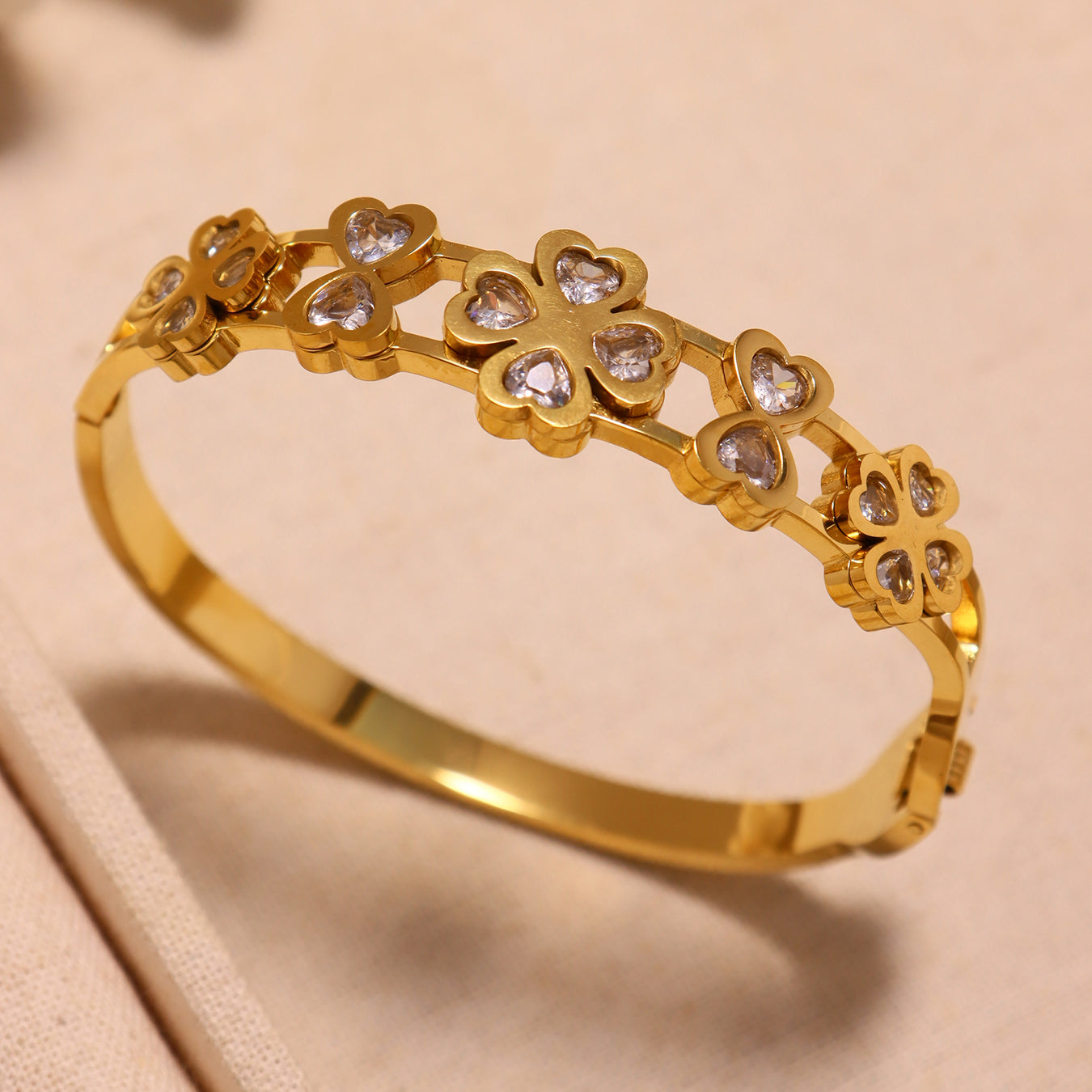 Closeup of 18k gold plated 5A zircon heart four-leaf flower bangle: intricate heart-flower details