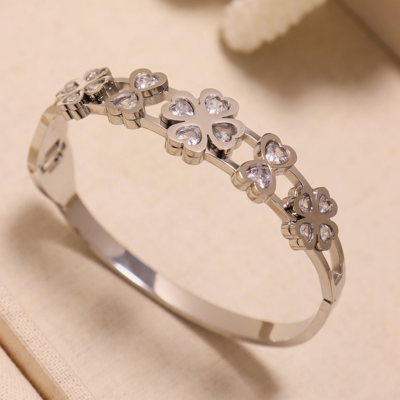 Closeup of 18k gold plated 5A zircon heart four-leaf flower bangle (silver): durable stainless steel