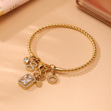 Closeup of gold 18k gold plated 5A zircon twist DIY bangle: intricate twist & charm details