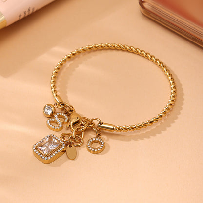 Closeup of gold 18k gold plated 5A zircon twist DIY bangle: intricate twist & charm details