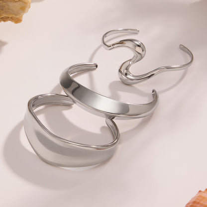 Silver 18k gold plated bold curved open bangle set, stacked on light background