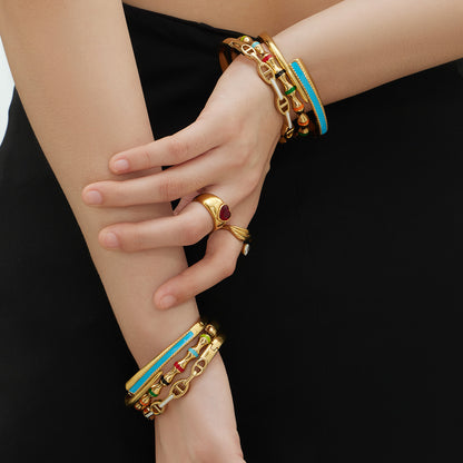 Closeup of 18k gold plated enamel clasp bangle set on model, side view detail