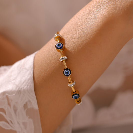 Close-up of 18K gold plated titanium steel evil eye enamel bracelet with rhinestones on wrist