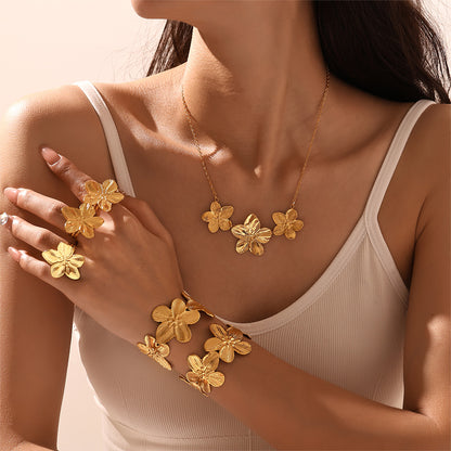 Model wearing 18k gold plated flower jewelry set: ring, necklace, bangle