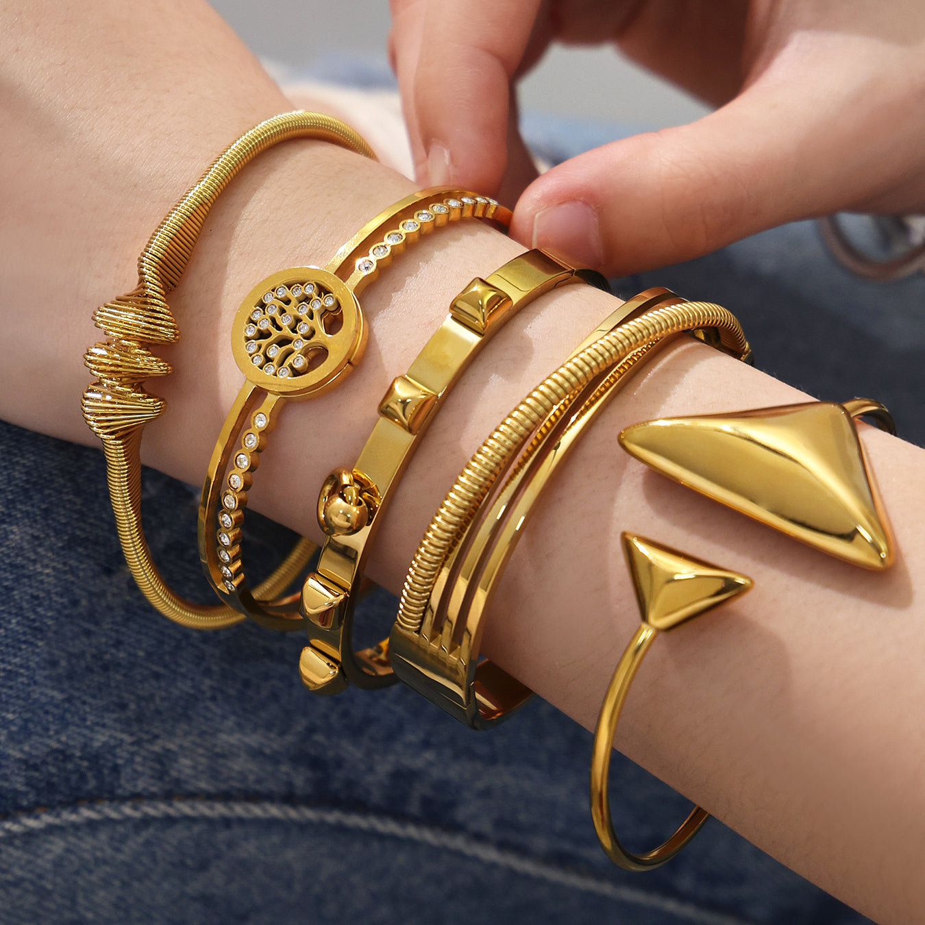 Closeup of 18k gold plated geometric open bangle set on wrist, irregular versatile design