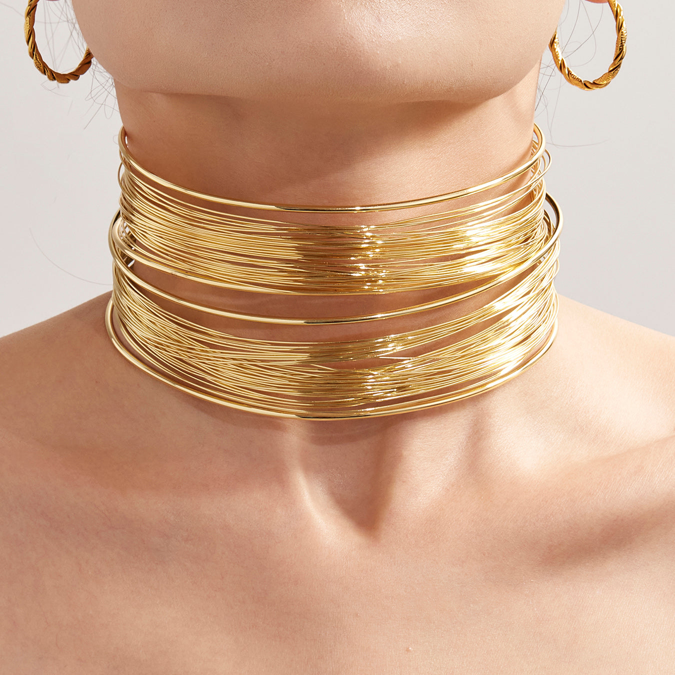 Closeup of 18k gold plated hand-wrapped brushed collar necklace on neck
