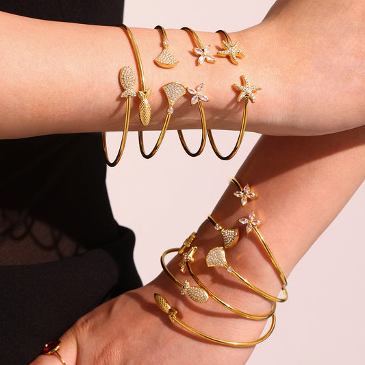 Double wrist stack of 18k gold plated ocean 5A zircon bangle set: fish starfish design