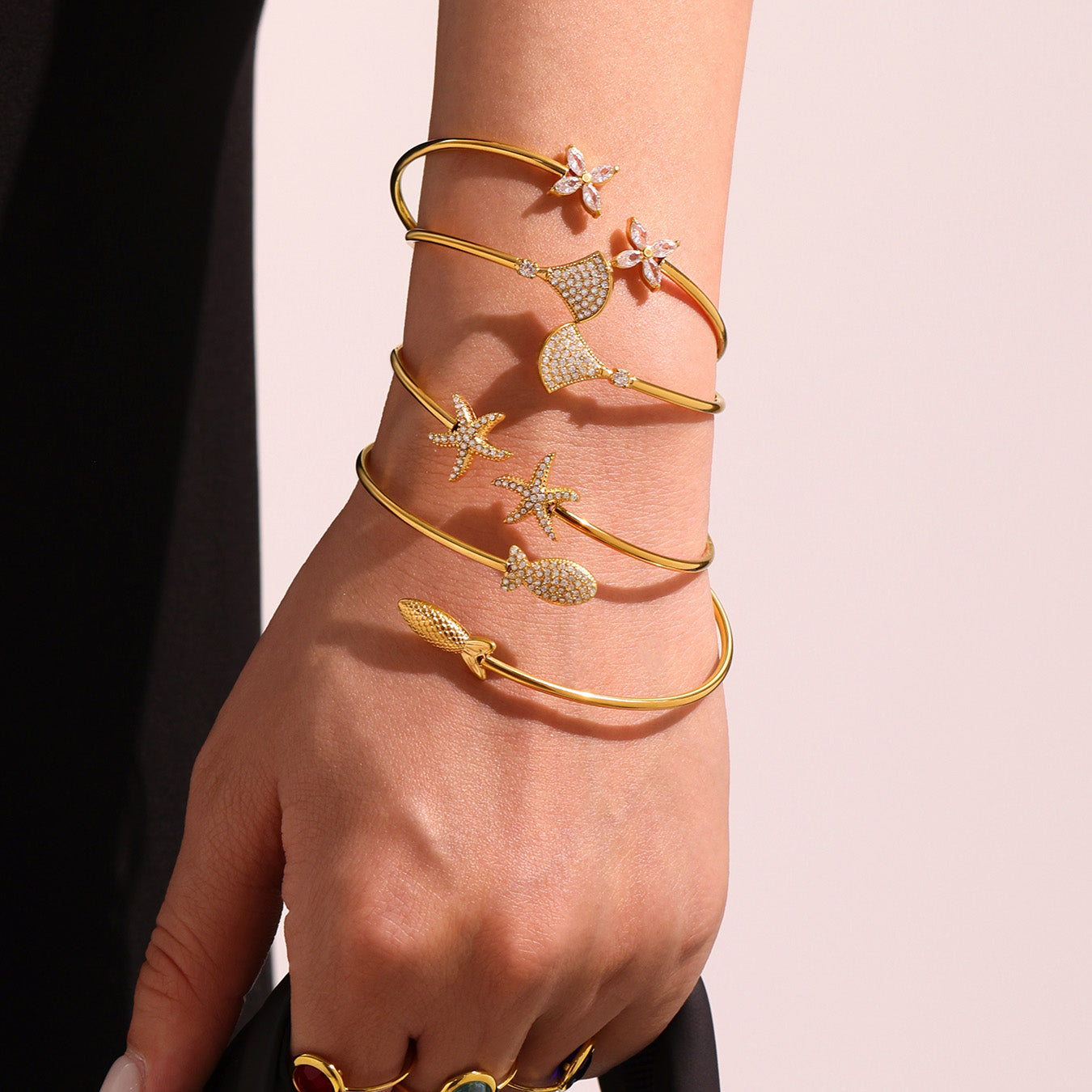 Closeup of 18k gold plated ocean 5A zircon bangle set stacked on single wrist