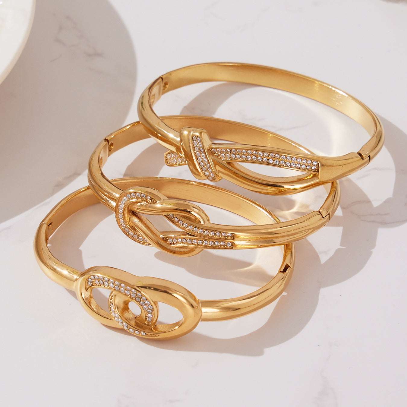 18K gold plated stainless steel bangle set with zircon-embellished knot clasp design