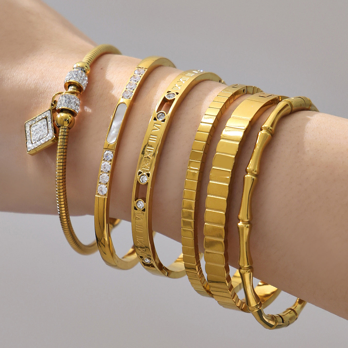 Women wearing 18k gold plated zircon bangle set, gold roman numeral bamboo bracelet