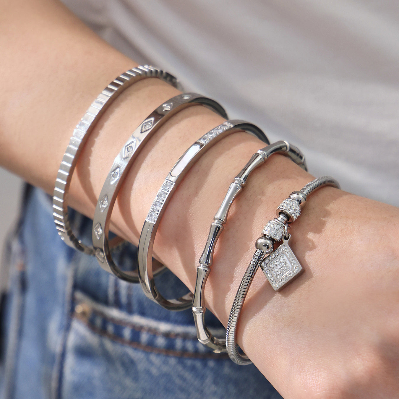 Women wearing 18k gold plated zircon bangle set, silver roman numeral bamboo bracelet