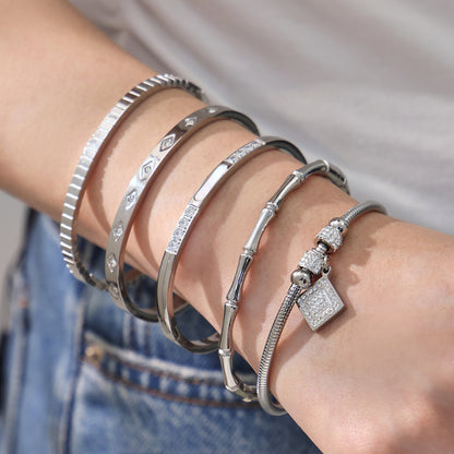 Women wearing 18k gold plated zircon bangle set, silver roman numeral bamboo bracelet