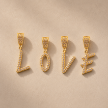 18K gold plated zircon LOVE letter pendant charms with sparkling clear stones on beige background