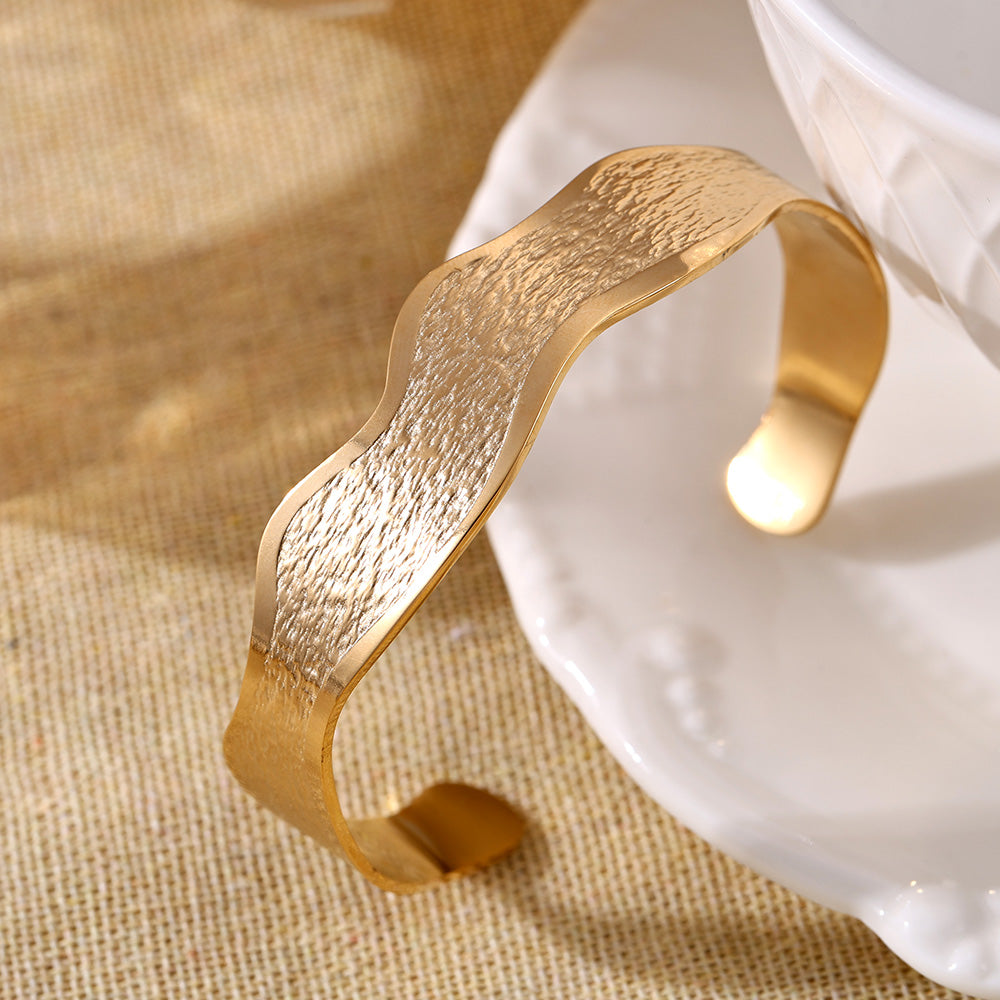 18K gold plated wave texture open bangle displayed on white dish, luxury daily accessory