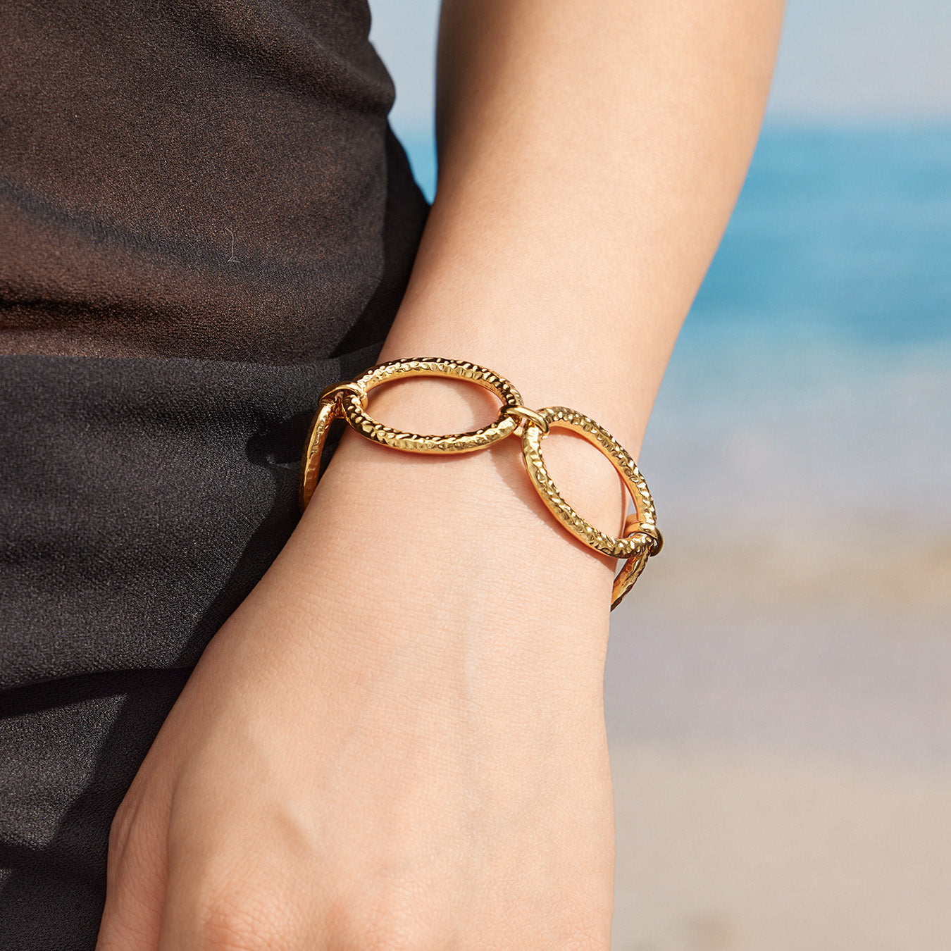 Close-up of an 18K PVD gold chunky link bracelet worn on the wrist