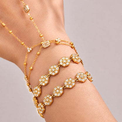 18K PVD gold flower bracelet styled with hand chain and rings, showing a giftable boutique jewelry look