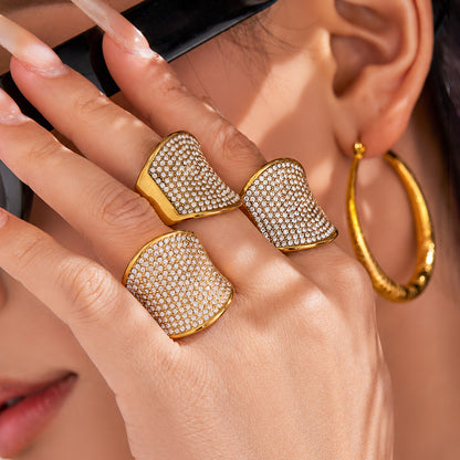 Hand close-up showing 18K PVD gold CZ statement ring with wide band pavé crystal surface