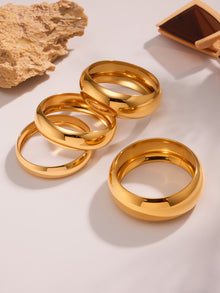 18k pvd gold plated stainless steel glossy wide cuff bracelets displayed with natural stone and sunglasses, stylish scene setup