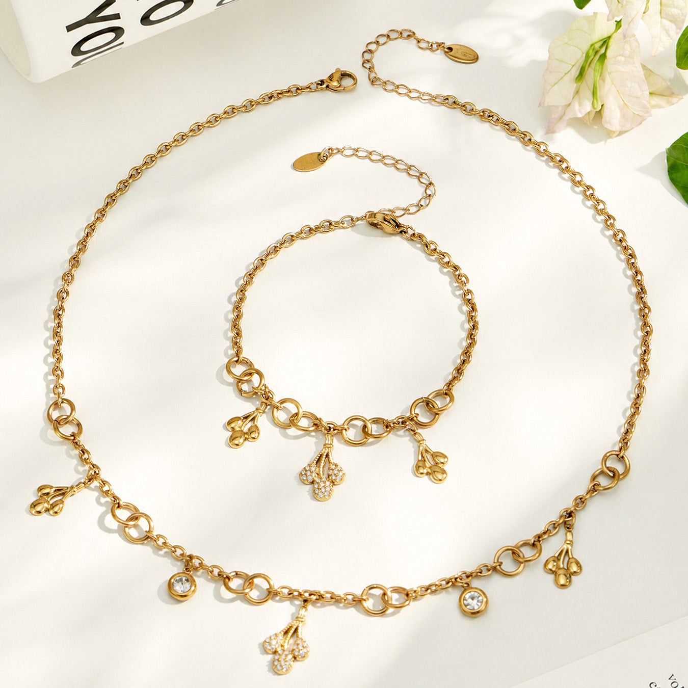 18K PVD gold teardrop zircon necklace and matching bracelet displayed together