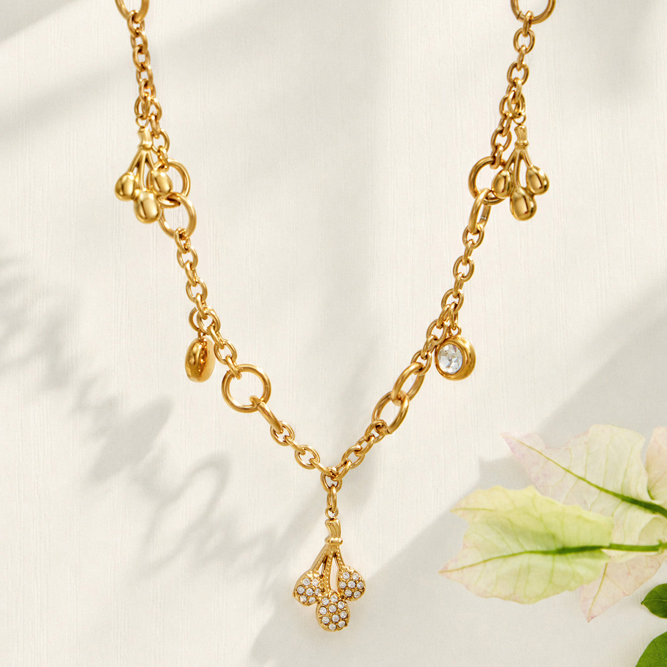 18K PVD gold teardrop zircon necklace displayed on a light fabric background