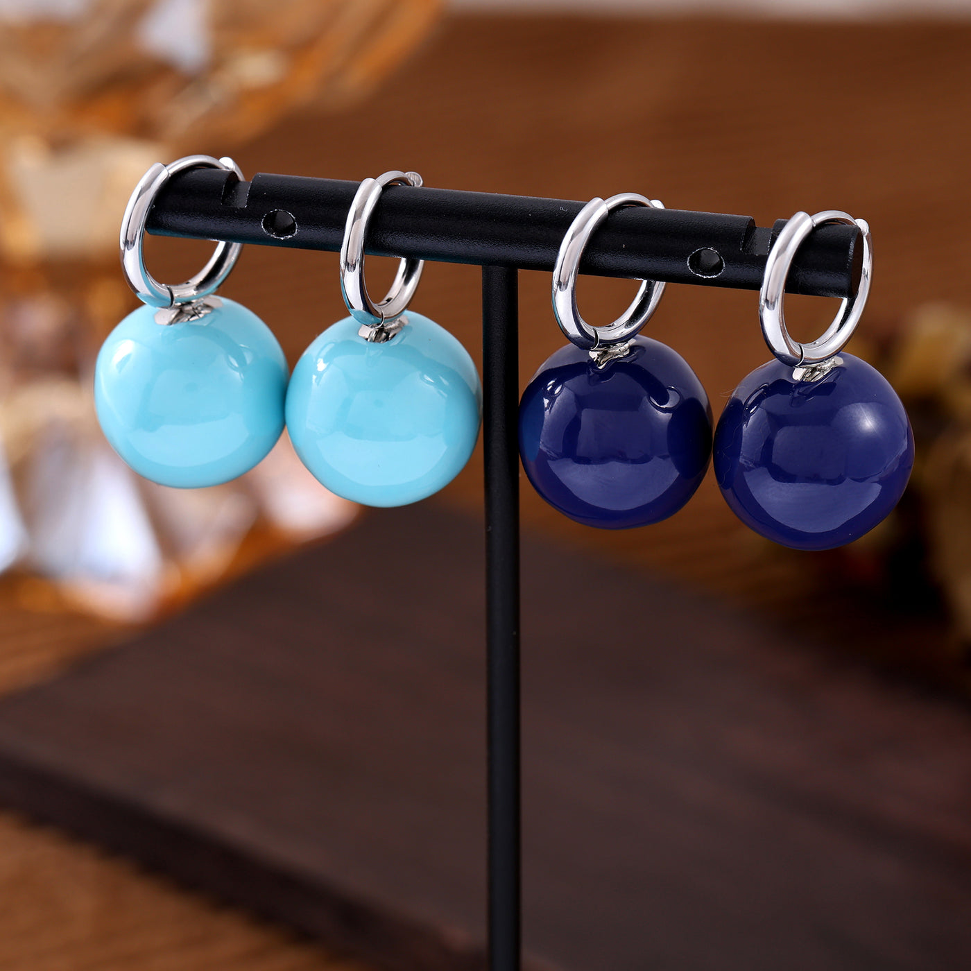 Light blue and navy ball drop hoop earrings displayed together