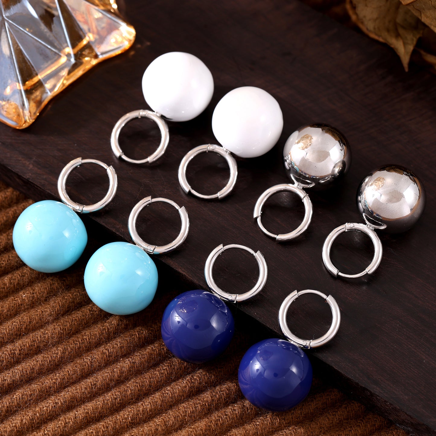Steel-tone hoop earrings with white, light blue and navy ball drops