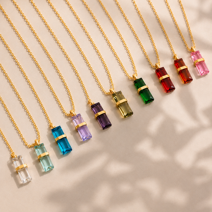 Flat lay display of 316L stainless steel 12-color birthstone crystal pendant necklaces in multiple colorful rectangular crystal variations.