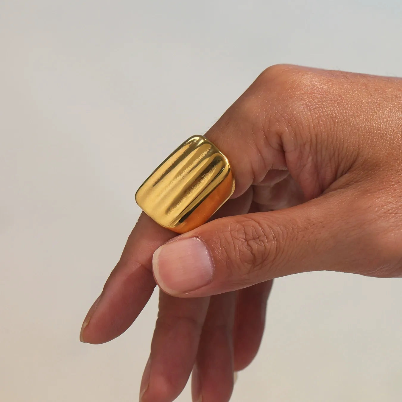 18K PVD gold geometric wide band ring close-up on hand