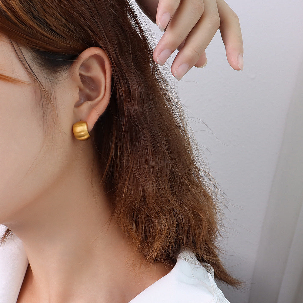 Side profile of model wearing waterproof 18K gold plated chunky C-shape hoop earrings for sensitive skin.
