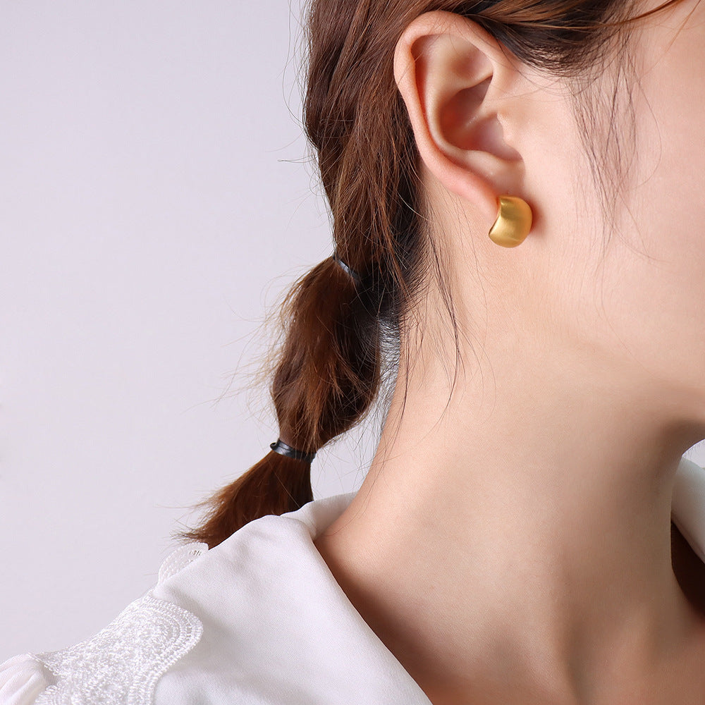 Model showcasing elegant tarnish-free 316L stainless steel matte gold C-shape hypoallergenic earrings.