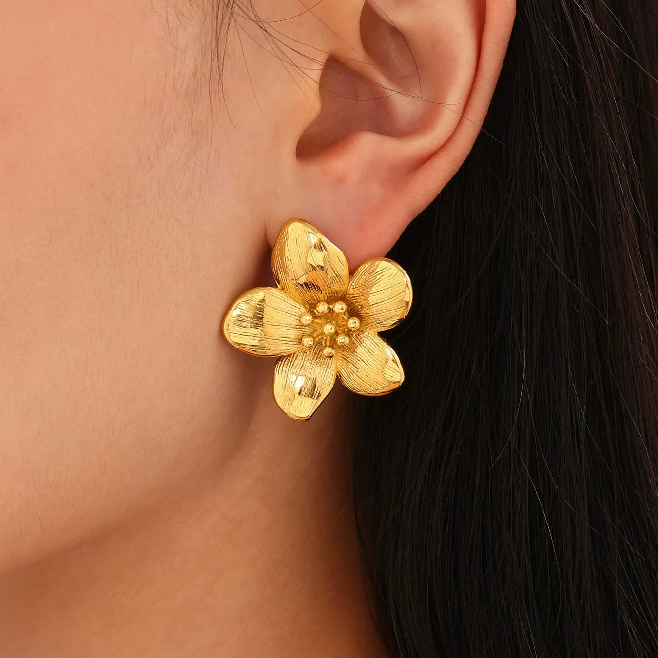 Side profile of model wearing waterproof 18K gold plated floral sunflower stud earrings for sensitive skin.