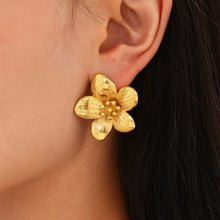 Side profile of model wearing waterproof 18K gold plated floral sunflower stud earrings for sensitive skin.