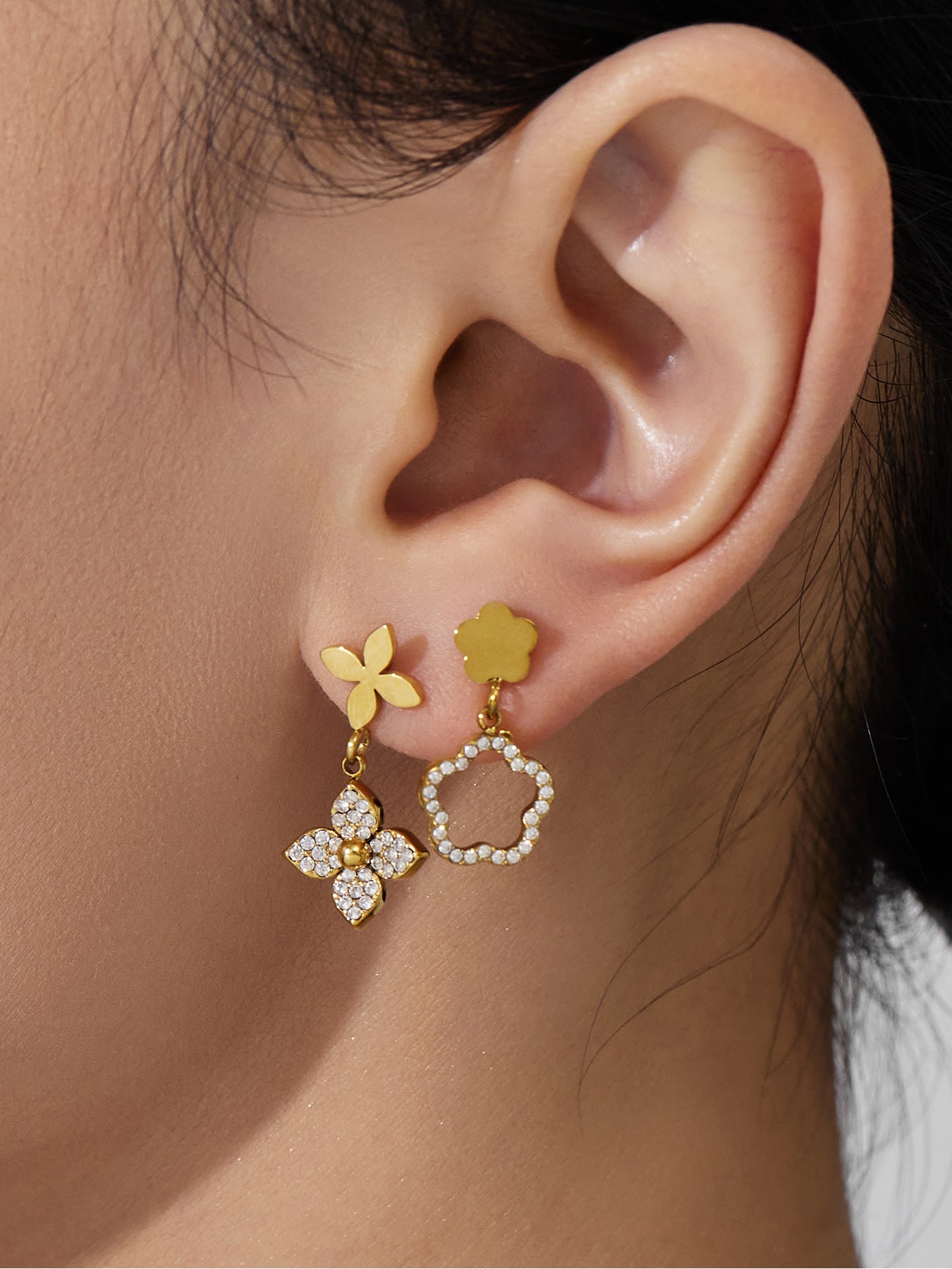 Dainty 18K gold plated clover-shaped stud earrings worn by a model, crafted from surgical grade stainless steel.