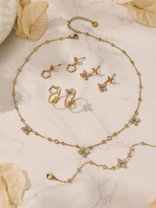 Professional product photography of the 18K gold plated geometric necklace, ring, earrings, and bracelet set.
