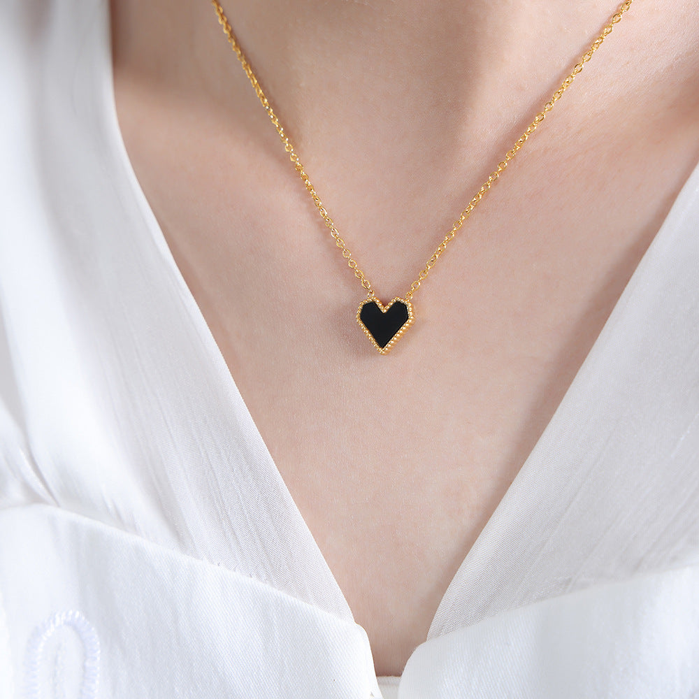 A minimalist black heart charm necklace in gold stainless steel, perfect for layering and sensitive skin.