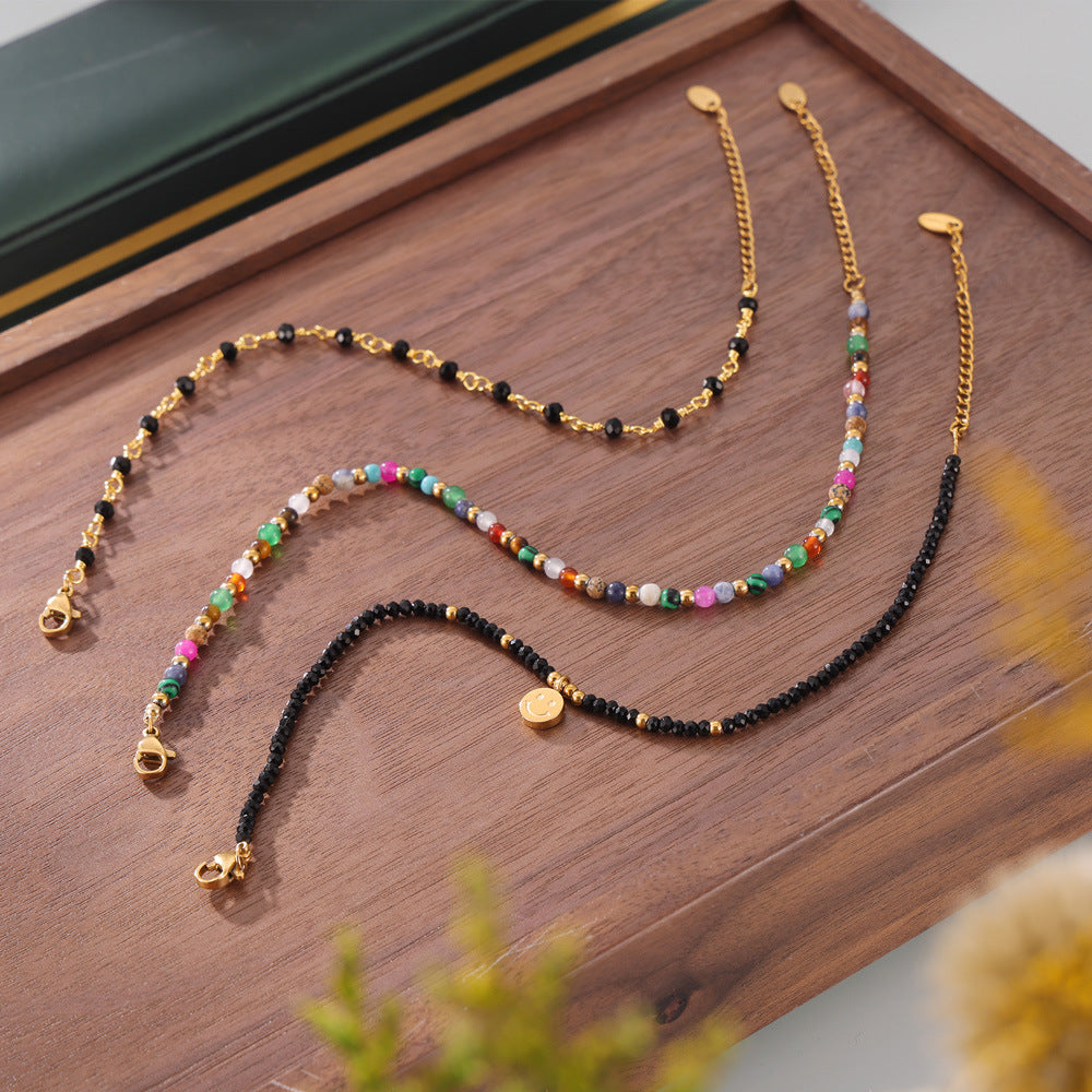 Styled shot of mixed-color natural stone beaded anklets in warm decor, vibrant multi-stone design for boho summer aesthetic