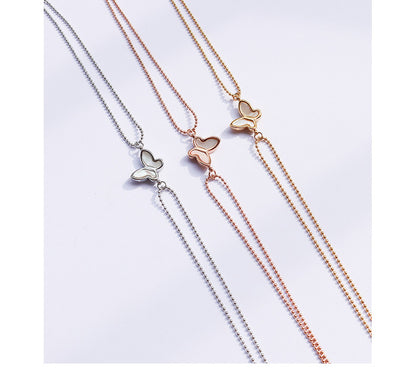 Silver-tone minimalist butterfly anklet with small charm worn on a foot in clear heels, lightweight 316L stainless steel design for everyday wear