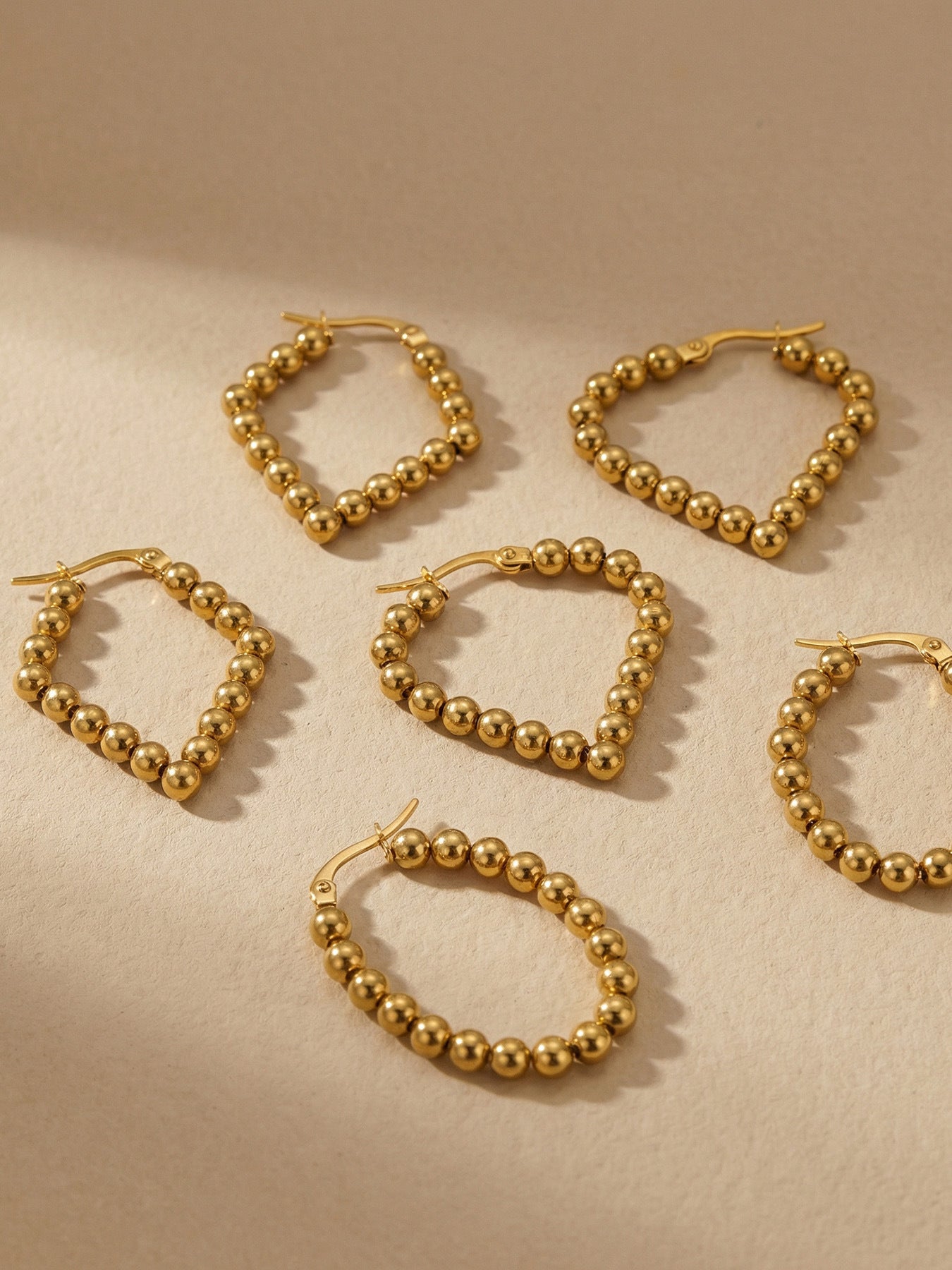 18K Gold PVD Twisted Hoop Earrings worn on ear, hypoallergenic stainless steel jewelry