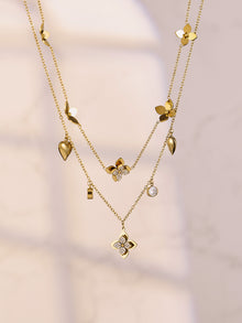 Elegant four-petal flower necklaces draped beautifully, showcasing the high-quality 18K gold PVD plating for wholesale buyers.