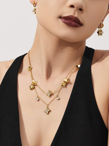 Close-up of a delicate four-petal flower pendant necklace on a model, highlighting its tarnish-resistant gold finish and zircon center.